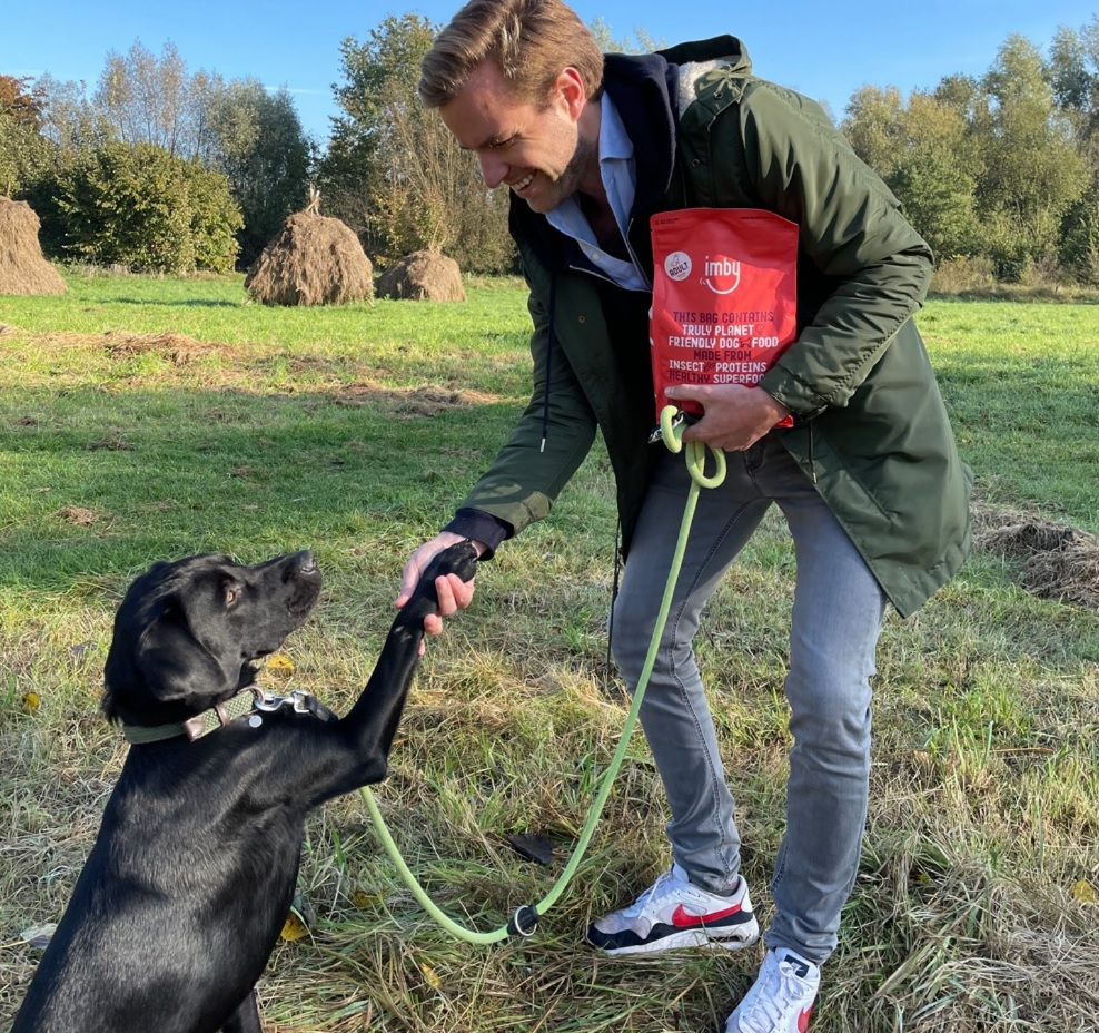 Een hond aan de lijn die zijn poot aan een mens geeft.